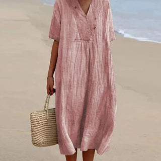 Robe bohème ample rose poudré, col en V, manches courtes, taille froncée.
