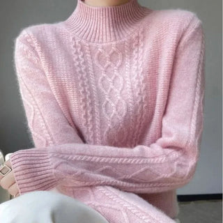 Pull col roulé rose en maille côtelée, motif torsadé devant.