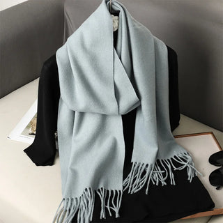 Écharpe gris pâle portée en étole, avec franges longues