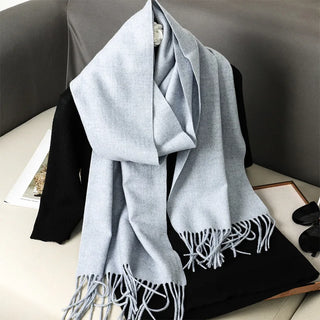 Grande étole gris clair à franges, drapée autour du cou