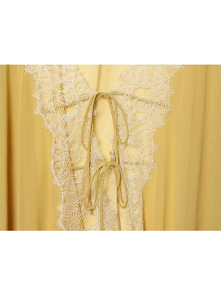 Détail des liens à nouer et de la dentelle écrue sur la blouse moutarde