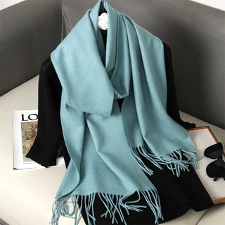 Grande écharpe bleu gris clair à franges, portée en étole
