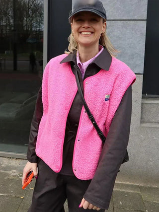 Gilet sans manches en polaire rose, fermeture zippée et col montant, finitions noires.