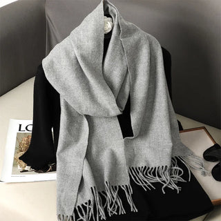 Écharpe en laine gris clair, nouée autour du cou et terminée par des franges.