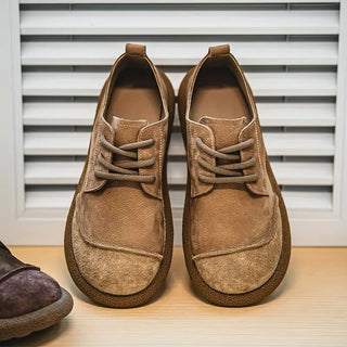 Chaussures en cuir de veau kaki, forme basse, lacets et empiècement sur l’empeigne.