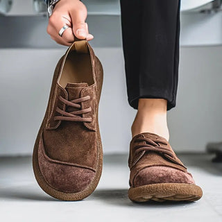 Chaussures en cuir de veau marron, tige basse, lacets et semelle texturée.