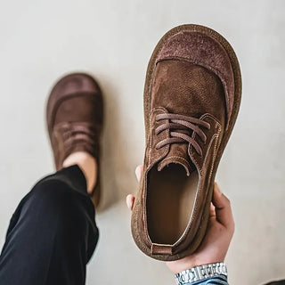 Chaussure en cuir de veau marron, vue de face, lacets, col rembourré et semelle épaisse.