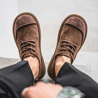 Chaussures en cuir de veau marron, dessus texturé, lacets et bout arrondi.