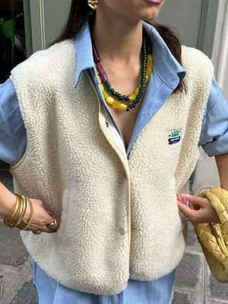 Gilet sans manches en polaire blanc cassé, fermeture zippée, logo discret sur la poitrine.