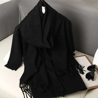 Écharpe en laine noire, longue et douce, avec franges aux extrémités.