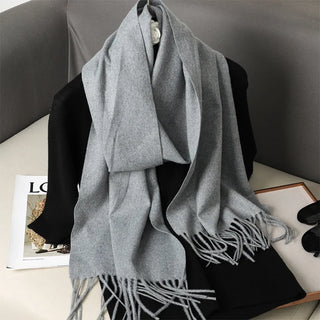 Étole en laine gris moyen, portée en drapé, avec longues franges.