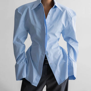 Chemise bleu clair à épaules structurées, col pointu et fermeture boutonnée
