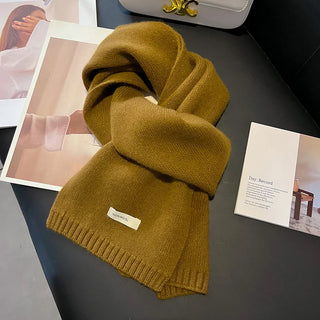 Écharpe en maille épaisse ocre, unie, avec bordures côtelées et étiquette cousue.