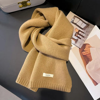 Écharpe en maille épaisse beige, unie, avec bordures côtelées et étiquette cousue.