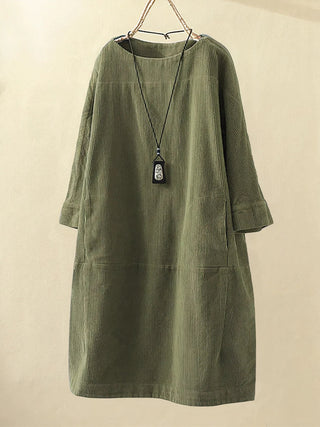 Robe tunique en velours côtelé vert foncé, col rond, manches trois-quarts, coupe droite.