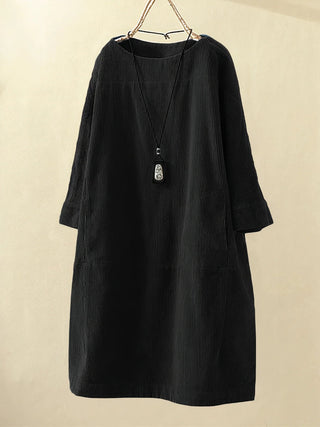 Robe tunique en velours côtelé noire, col rond, manches trois-quarts, coupe droite.