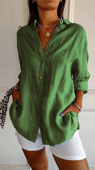 Chemise ample en coton verte boutonnée, col chemise, manches retroussées.