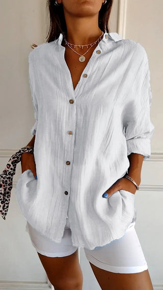 Chemise ample en coton blanche boutonnée, col chemise, manches 3/4 retroussées.