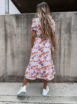 Robe fleurie à fond clair et fleurs colorées, col V boutonné, manches bouffantes, fente.