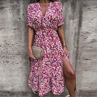 Robe fleurie rose et violette, col V boutonné, manches bouffantes, fente sur le côté.