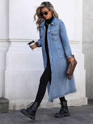 Veste longue en jean bleu, boutonnée, col chemise, poches poitrine, effet délavé.