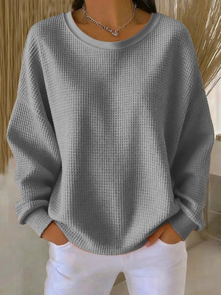 Pull long femme en tricot gaufré gris, manches longues, col rond.